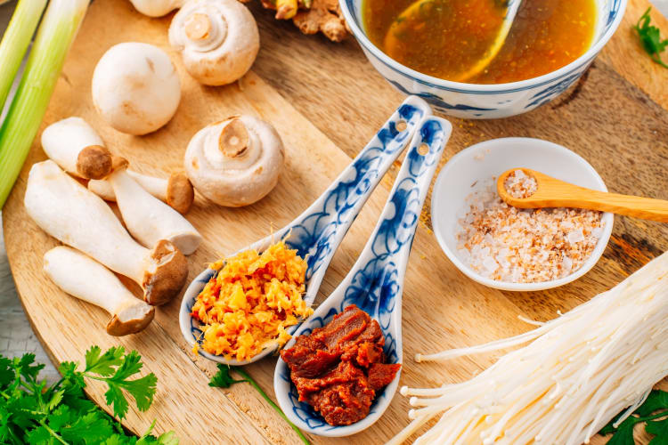 Spoons of miso paste and mushrooms on a board