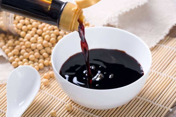 A bowl with soy sauce being poured into it