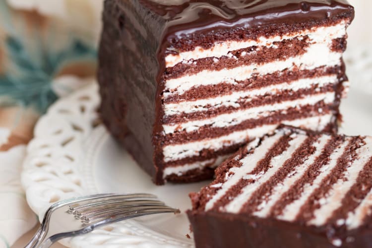 Two slices of a layered chocolate cake on a white plate