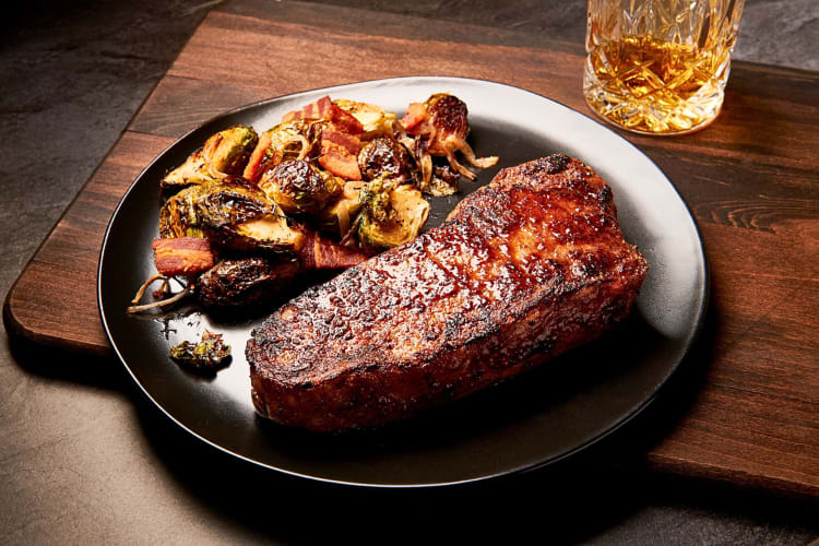 Steak and vegetables on a black plate, from Morton's The Steakhouse