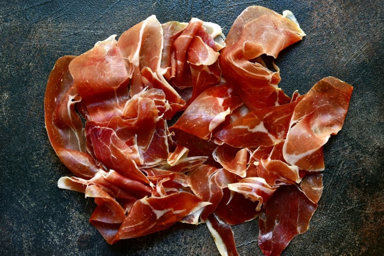 Iberico ham slices on a slate surface