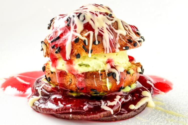 A profiterole dessert with pink sauce