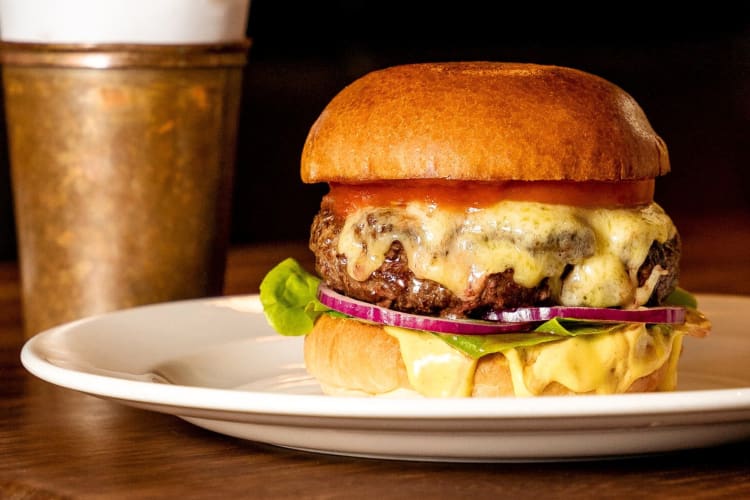 A burger on a plate on a wooden table