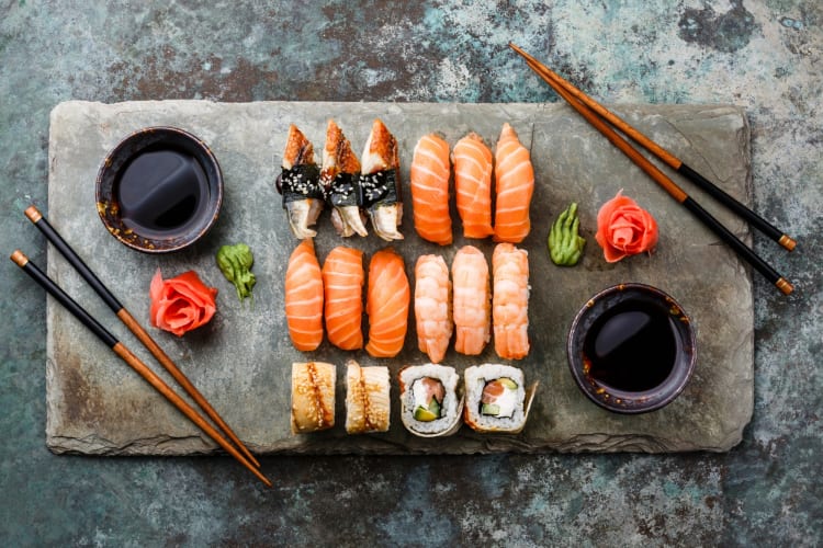 Sushi on a slate with chopsticks on either side