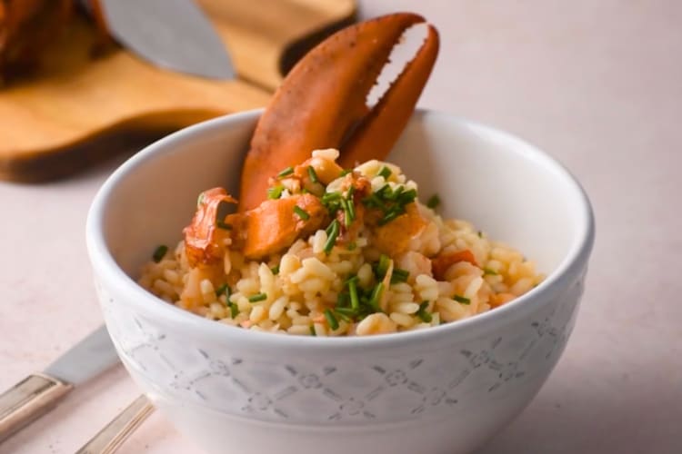 A bowl with risotto and a lobster claw