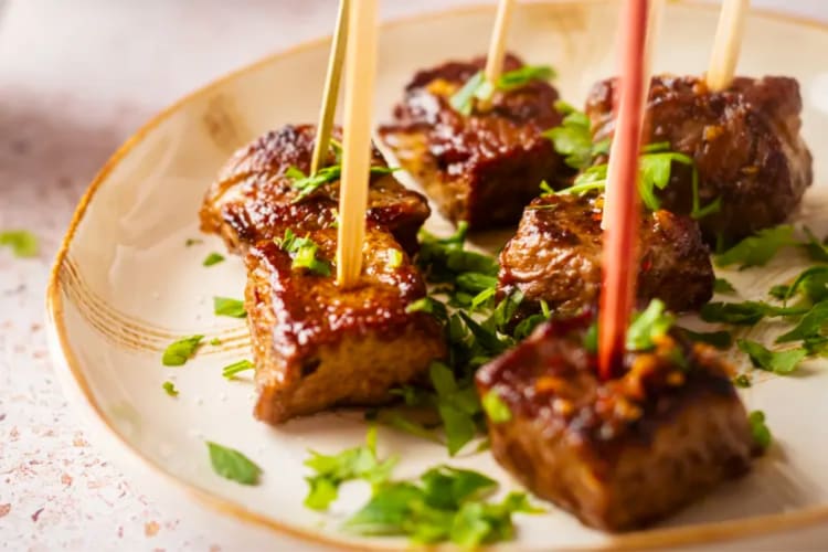 Steak bites on a plate sprinkled with cilantro