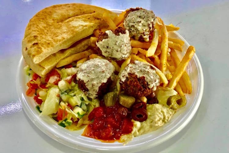 Pita bread, falafel balls, vegetable toppings and fries from Moty’s Grill in Miami