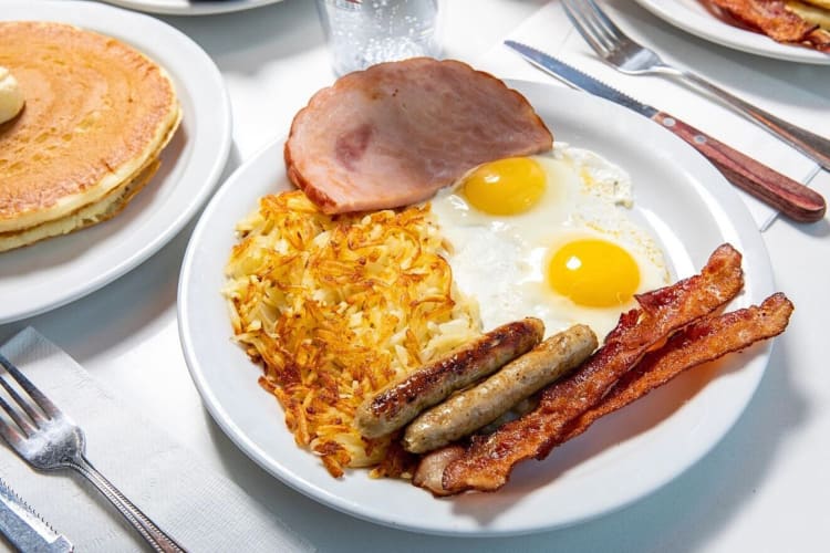 A breakfast with bacon, sausages, hash browns, eggs and ham, from NORMS Restaurant