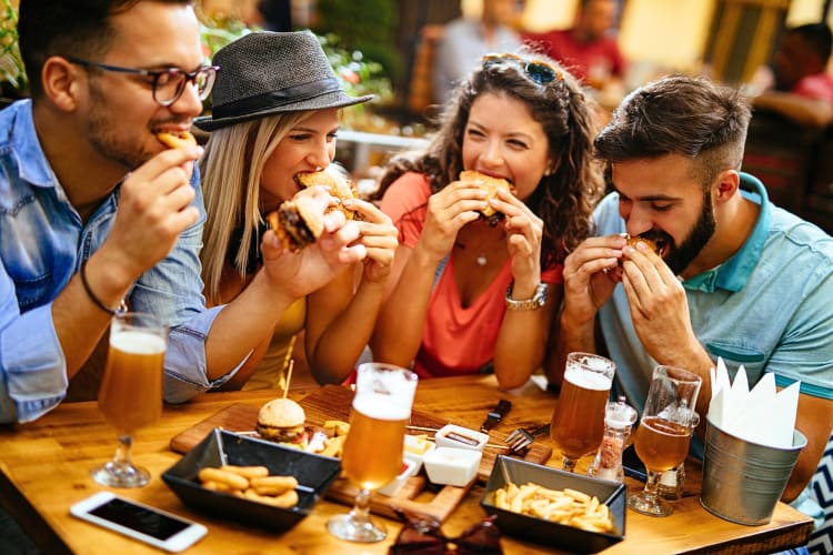 Four friends eating food at a restaurant