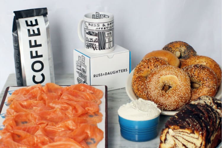 A selection of bagels, salmon, coffee and a mug