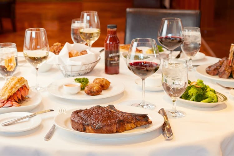 A selection of steakhouses dishes and wine glasses on a table