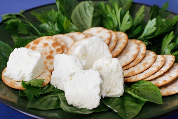 Goat cheese, crackers and spinach on a plate