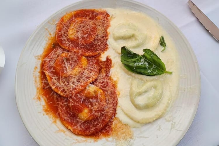 Half-and-half ravioli with spinach, pecorino, ricotta, parmigiana, lemon cream and tomato sauce