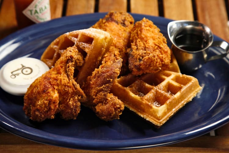 Chicken and waffles served with maple syrup and butter
