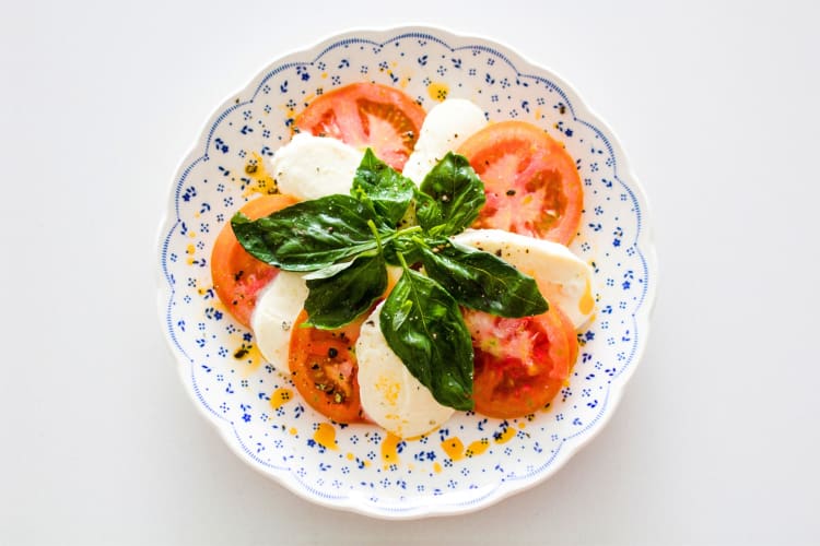 Tomatoes, mozzarella slices and basil on a plate