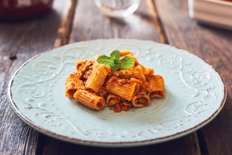 A plate with rigatoni pasta and a ragu sauce