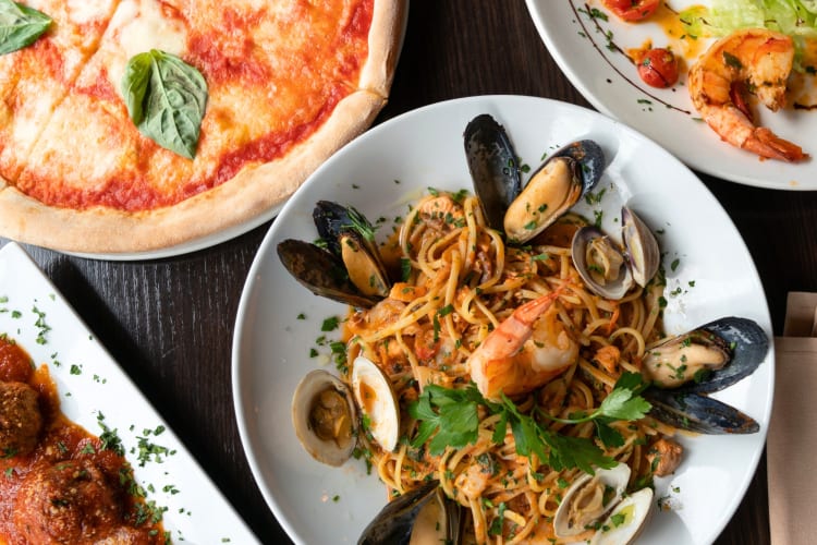 Seafood pasta and a pizza on a table