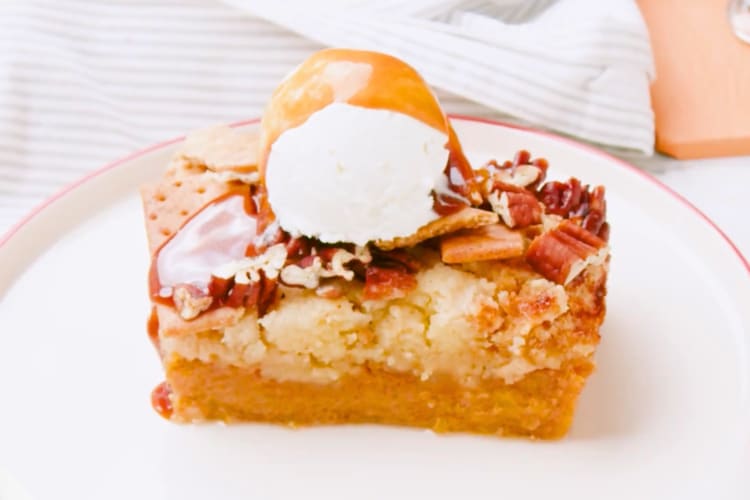 A pumpkin cake dessert with vanilla ice cream and caramel sauce