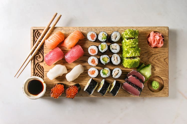 Aerial shot of 30 pieces of sushi on a wooden board