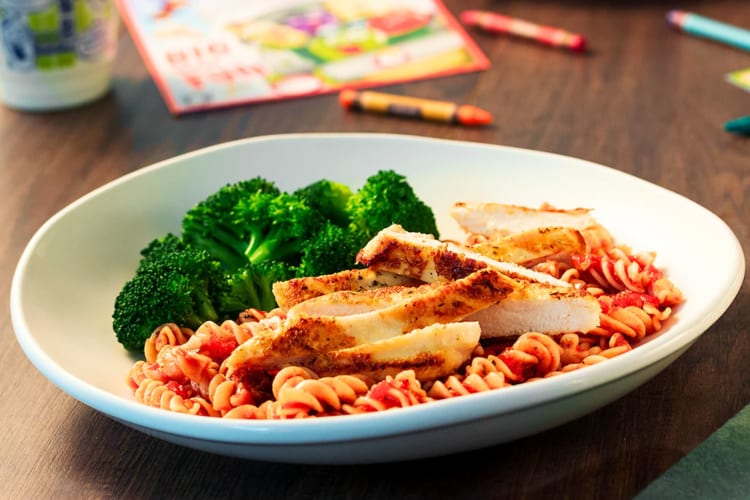 a child's meal with tomato pasta, grilled chicken and broccoli