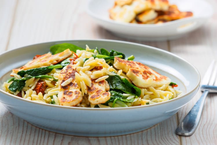 A bowl of orzo with halloumi and spinach