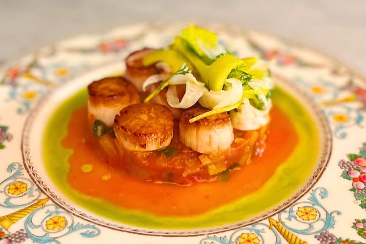 Seared scallops on a bed of purée and topped with fennel salad