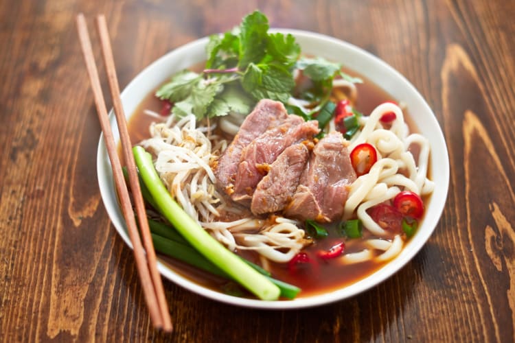 A bowl of pho with beef