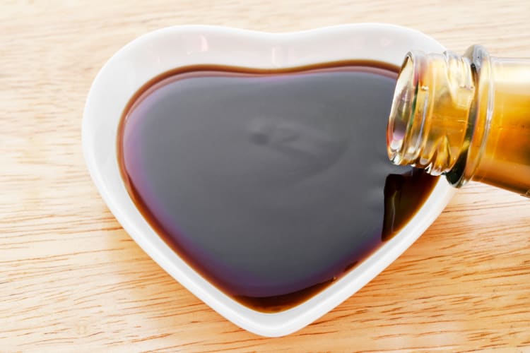 A heart shaped dish with a brown sauce in it