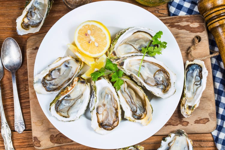 Oysters on a plate with garnish and lemon slices