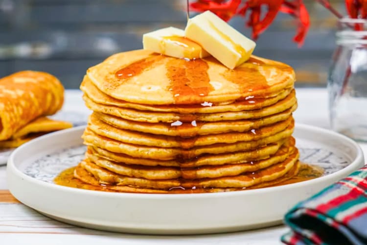 A stack of pancakes with butter and maple syrup