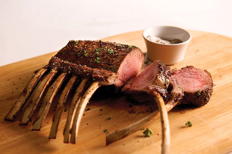 Ribs and a bowl of spices on a wooden surface, from Pappas Bros. Steakhouse