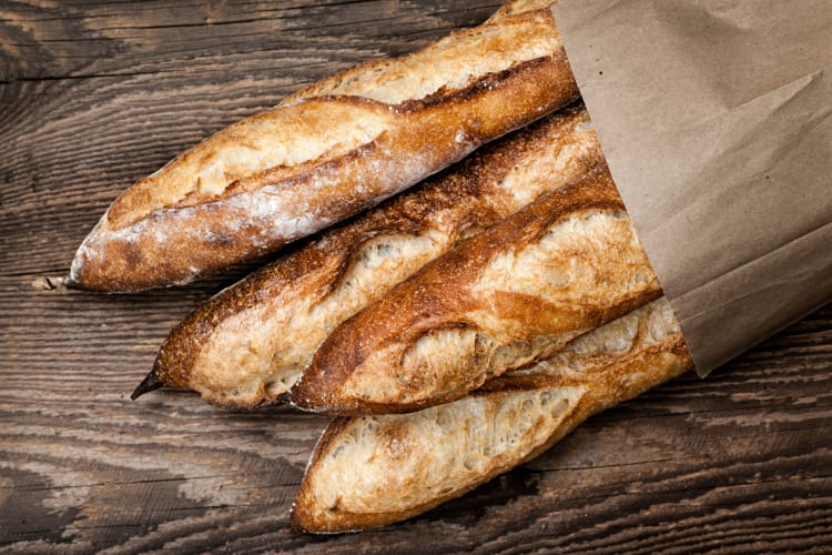 Four baguettes in a paper bag