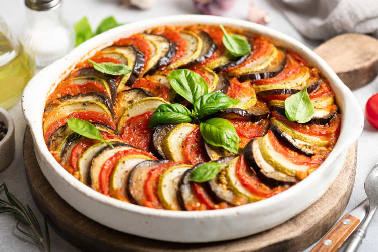 A dish of ratatouille with vegetables and basil