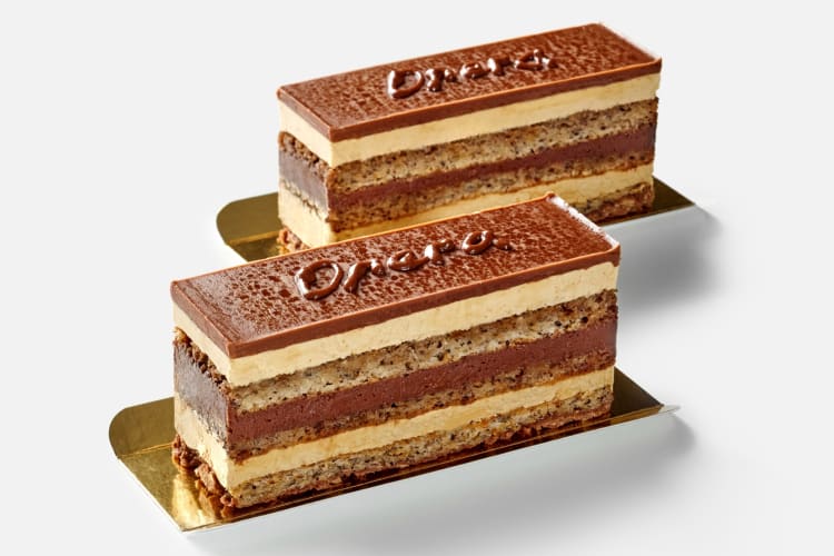 Two slices of layered cake with chocolate ganace and 