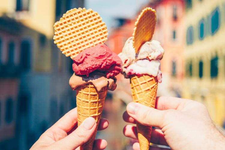 Two people holding ice cream cones with gelato