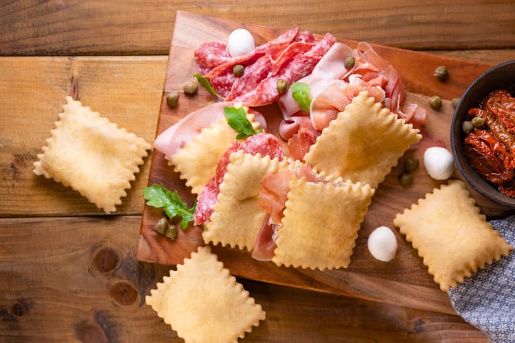 Cured meat and fried crackers on a board