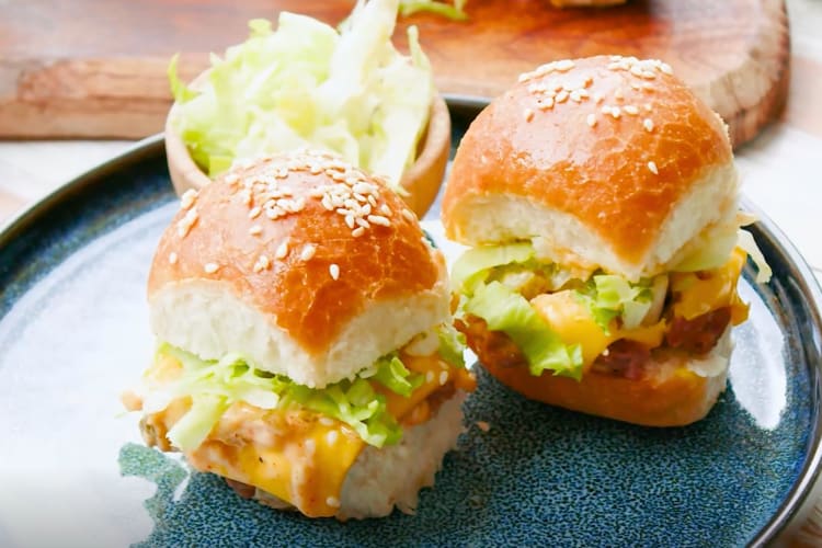 Two cheeseburger sliders on a blue plate