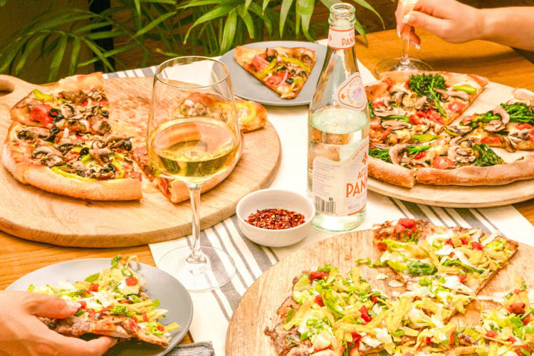 Pizzas and wine on an outdoor table