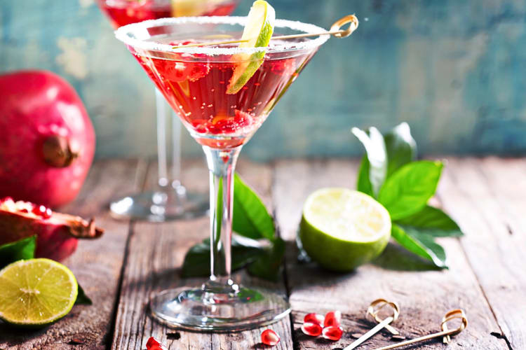 A pomegranate martini vodka cocktail on a wooden surface