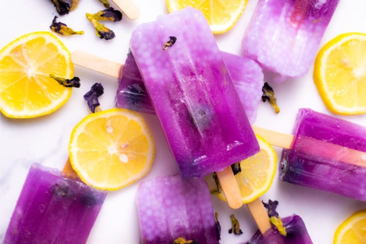 Purple popsicles with lemon slices around them