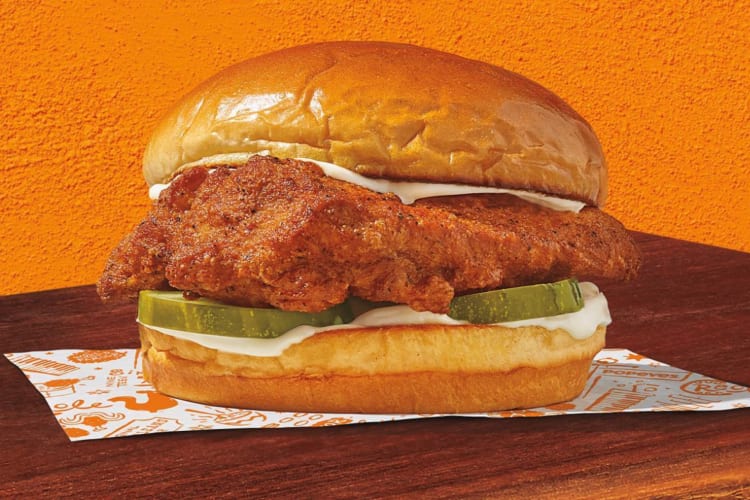 A chicken sandwich with ranch and pickles