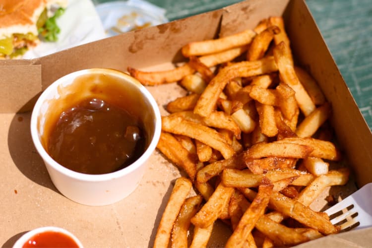 Take-out fries next to a container of gravy