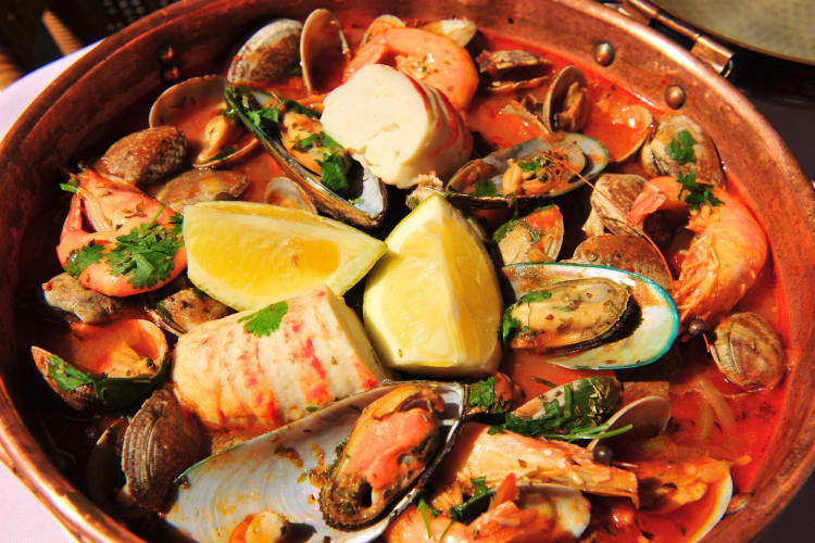 A fish stew with various shellfish in a tomato broth