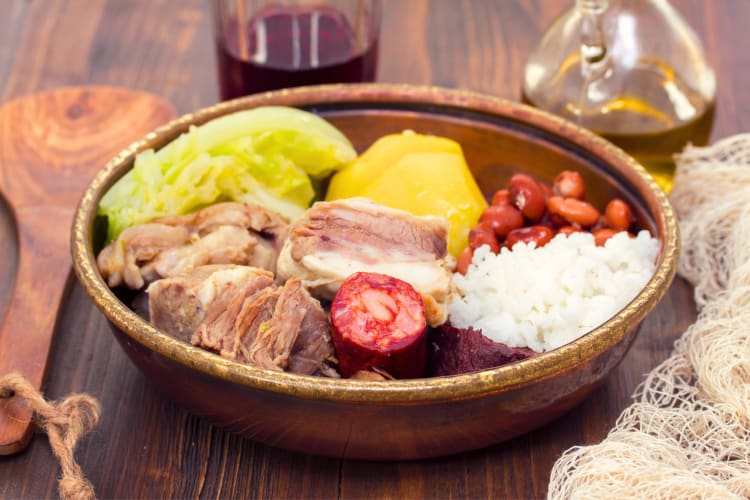 A bowl of stew with meat, beans and vegetables