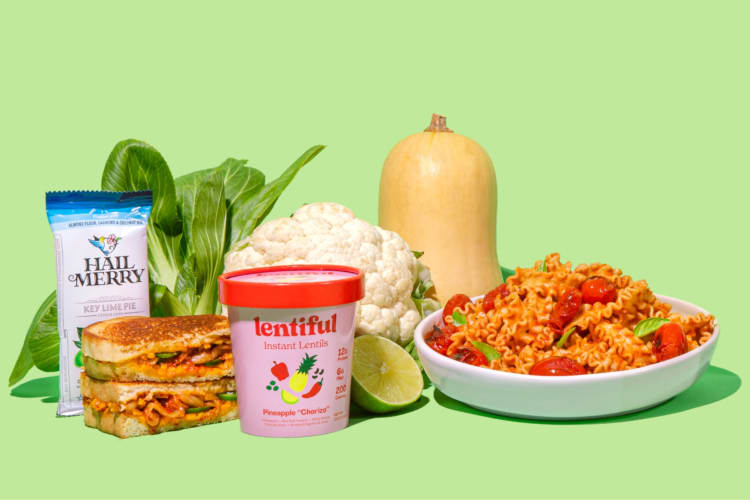 A bowl of pasta, vegetables, and packaged goods on a bright green background