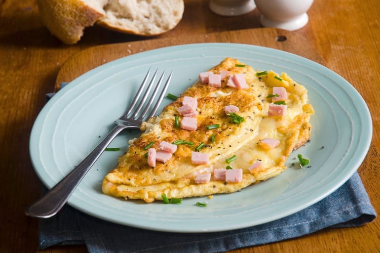 Ham and cheese omelette on a plate with a fork on it
