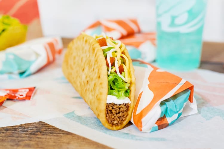 A soft shell taco next to a blue drink