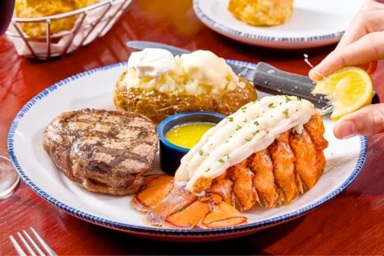 Steak, lobster and baked potato on a plate
