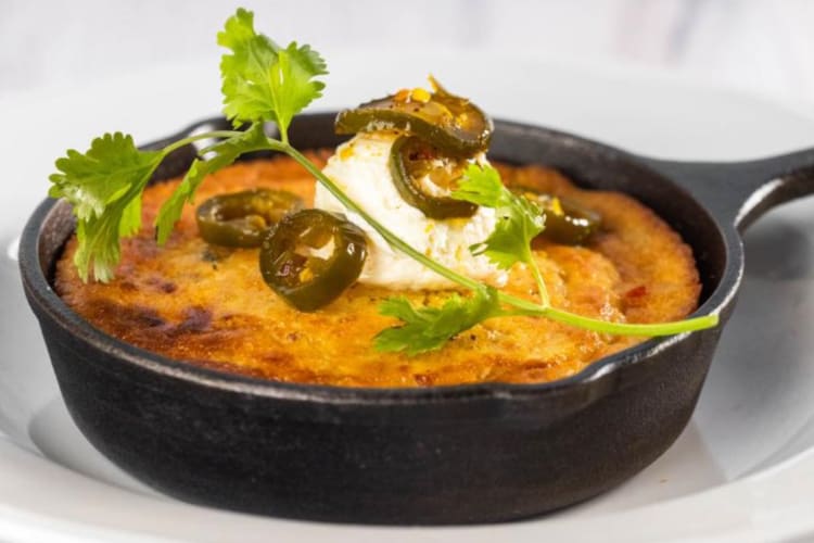 A cornbread skillet topped with jalapeño