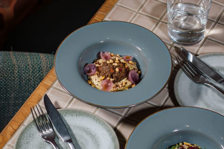 An Eastern Mediterranean dish on a table with a glass of water